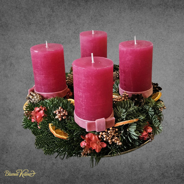 Klassischer Adventskranz mit frischem Tannengrün und vier weinroten Kerzen aus Zürich