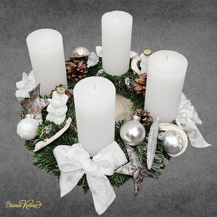Adventskranz aus frischer Tanne weiss dekoriert mit Kerzen Maschen und Zapfen aus Zürich