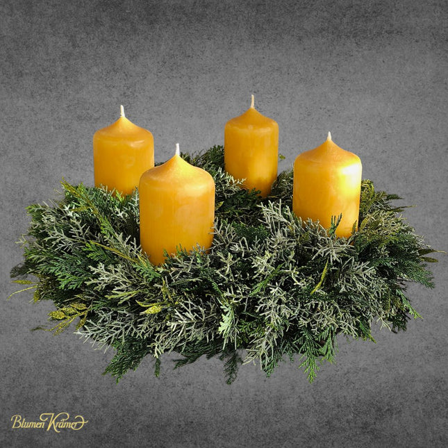 Adventskranz aus verschiedenen Koniferen mit vier natürlichen Bienenwachskerzen
