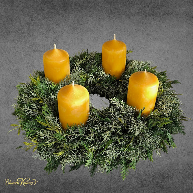 Adventskranz aus verschiedenen Koniferen mit vier natürlichen Bienenwachskerzen