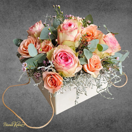 Blumenbox mit apricotfarbenen und rosigen Rosen Eukalyptus und feinen Blueten stilvoll arrangiert aus Zürich