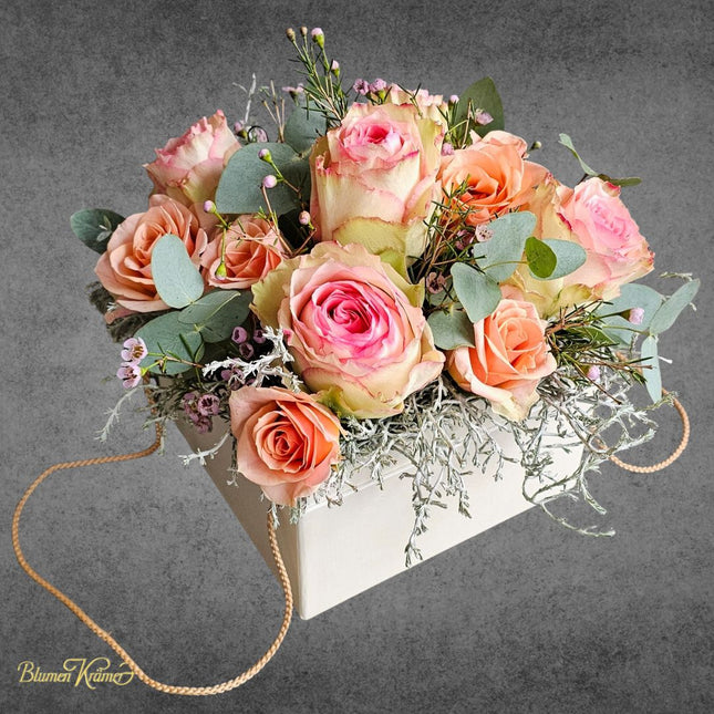 Blumenbox mit apricotfarbenen und rosigen Rosen Eukalyptus und feinen Blueten stilvoll arrangiert aus Zürich