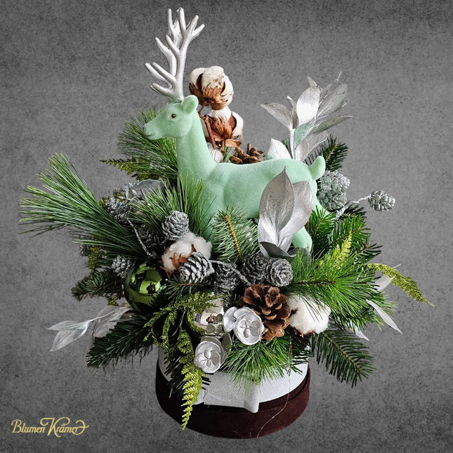 Weihnachtliche Blumenbox mit mintgrünem Hirsch und Tannenzweigen Silberblättern und Zapfen in Zürich verschicken