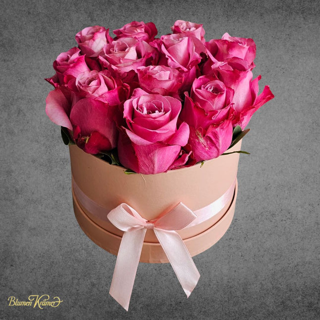 Elegante Rosenbox mit pinken Rosen in runder Geschenkbox mit Schleife, luxuriöses Blumengeschenk Zürich