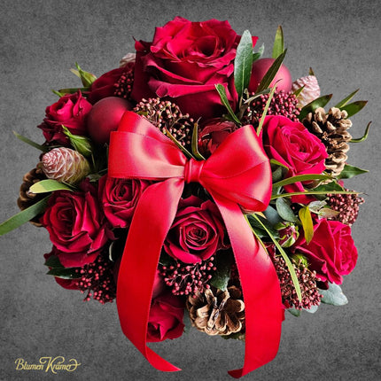 Weihnachtlicher Blumenkorb mit roten Rosen Zapfen und winterlichen Akzenten aus Zürich