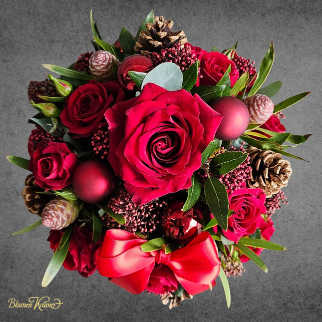 Weihnachtlicher Blumenkorb mit roten Rosen Zapfen und winterlichen Akzenten aus Zürich