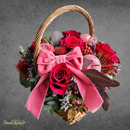 Weihnachtlicher Blumenkorb mit roten Rosen Samtschleife Winteräpfeln und Hagebute in Zürich online kaufen