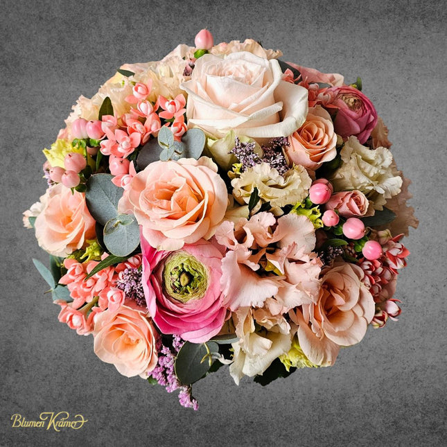 Eleganter Blumenkorb mit Rosen, Ranunkeln, Lisianthus und Pastellblüten in Rosé und Apricot, saisonal handarrangiert Zürich liefern lassen
