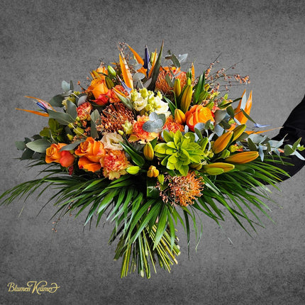 Exotischer orangefarbener Blumenstrauss mit Protea und Strelitzen frisch gebunden in Zürich