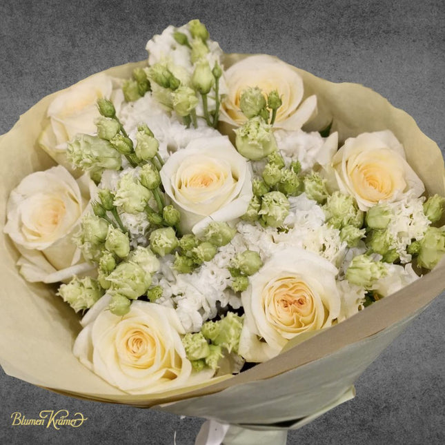Eleganter Blumenstrauss mit cremefarbenen Rosen und weissem Lisianthus, harmonisch gebunden in sanften neutralen Farbtönen
