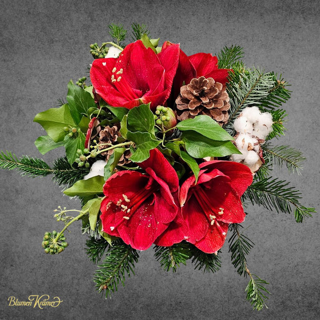 Weihnachtsstrauss mit roten Amaryllis Tannenzweigen Baumwolle und Zapfen liebevoll gebunden in Zürich
