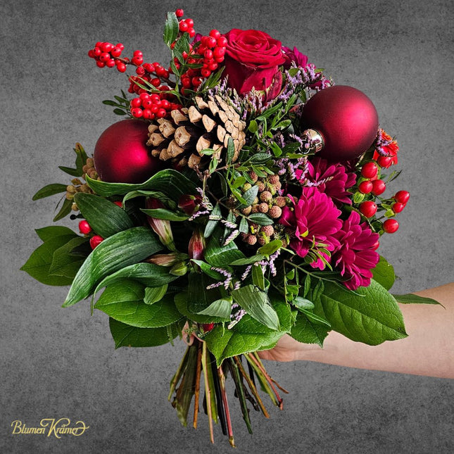 Weihnachtlicher Blumenstrauss in Rot mit Rosen Beeren Zapfen und Weihnachtskugeln aus Zürich