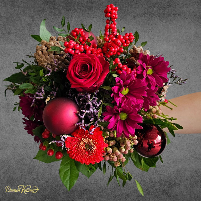Weihnachtlicher Blumenstrauss in Rot mit Rosen Beeren Zapfen und Weihnachtskugeln aus Zürich
