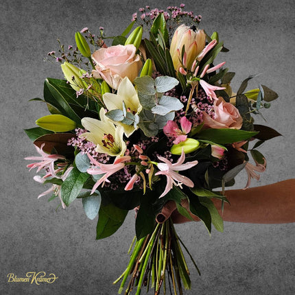 Winterblumenstrauss mit rosa Rosen und weissen Lilien handgebunden in Zürich