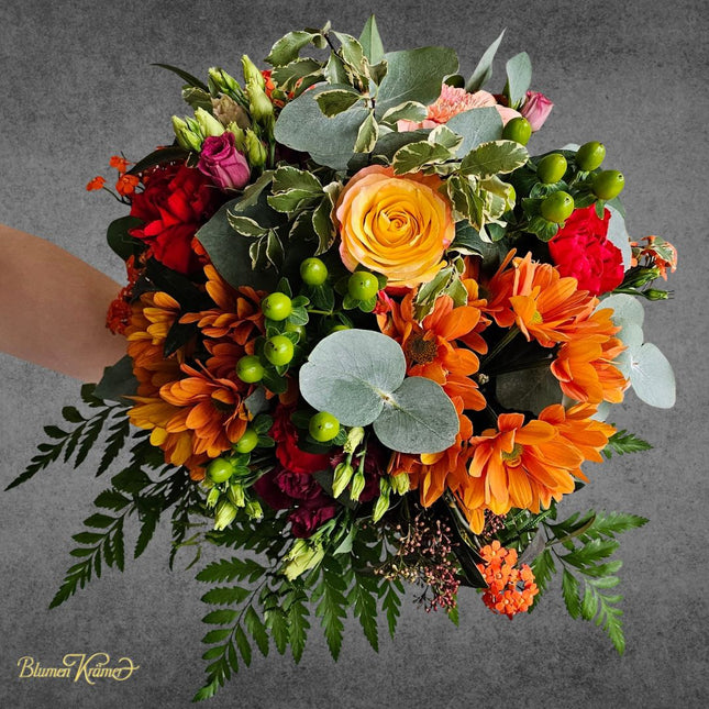 Blumenstrauss mit leuchtenden Chrysanthemen Rosen und grünem Hypericum in Orange Rot Gelb in Zürich