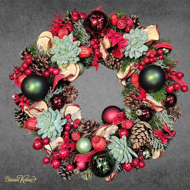 Moderner Adventskranz mit Tannengrün roten Beeren Kugeln Zapfen und Sukkulenten als Weihnachtsdeko in Zürich