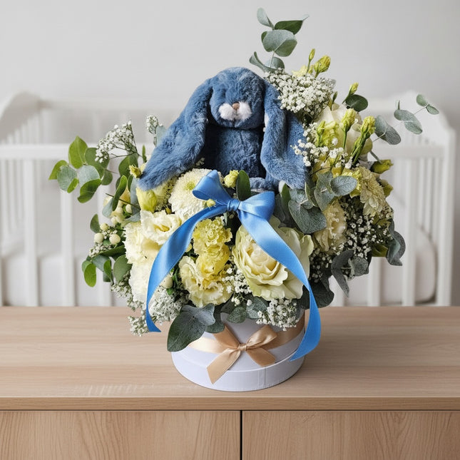 Liebevolle Blumenbox mit weissen Blumen und blauem Kuschelhasen als Baby Geschenk zur Geburt Zürich