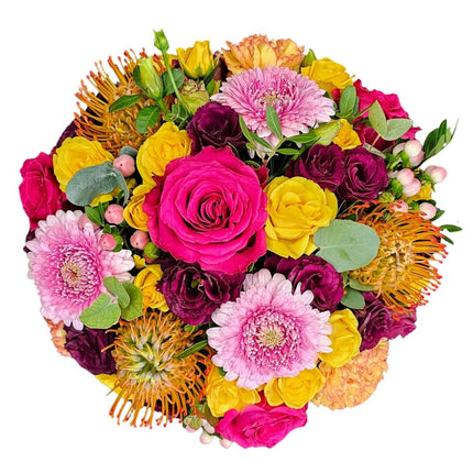 Farbenfroher Blumenkorb mit pinken und gelben Rosen, rosa Chrysanthemen, bordeauxfarbenen Blüten und saisonalen Blumen