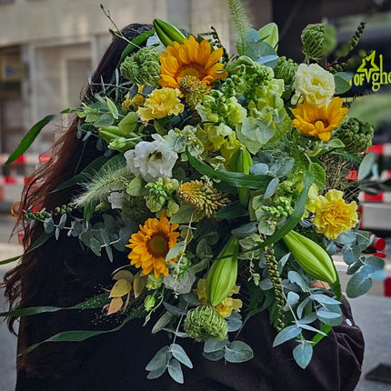 Üppiger Blumenstrauss mit Sonnenblumen, gelben Nelken, weissen Blüten, Lilien, Eukalyptus und saisonalem Grün