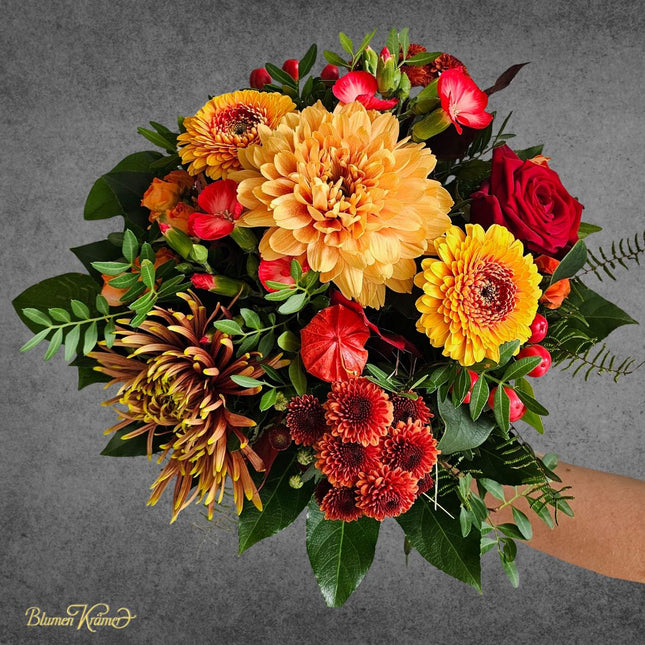 Herbststrauss mit leuchtend gelber Chrysantheme im Mittelpunkt und Blüten in Rot und Braun frisch geliefert vom Floristen in Zürich